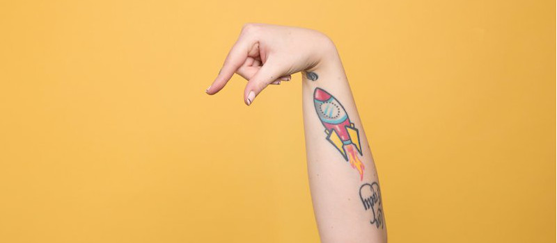 sfondo giallo mano con tatuaggi indica in basso