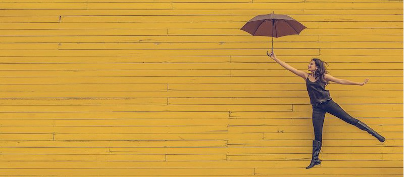 ragazza con ombrello sfondo giallo